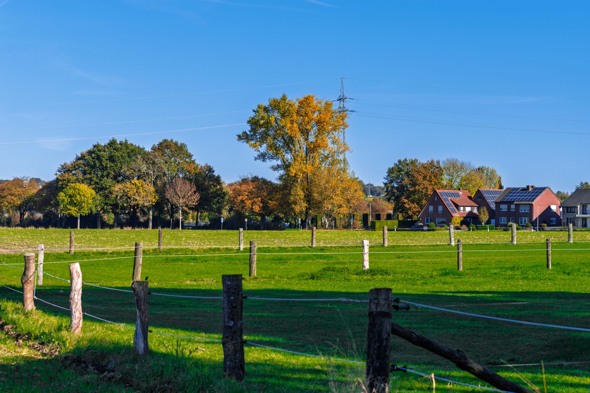 A wide rural farmland property with open fields and a distant treeline