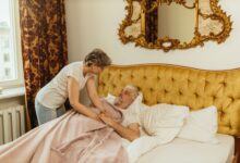 A home health aide assisting an elderly patient in a residential setting