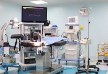 A modern hospital operating room prepared for a surgical procedure with anesthesia equipment visible
