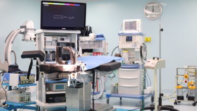 A modern hospital operating room prepared for a surgical procedure with anesthesia equipment visible