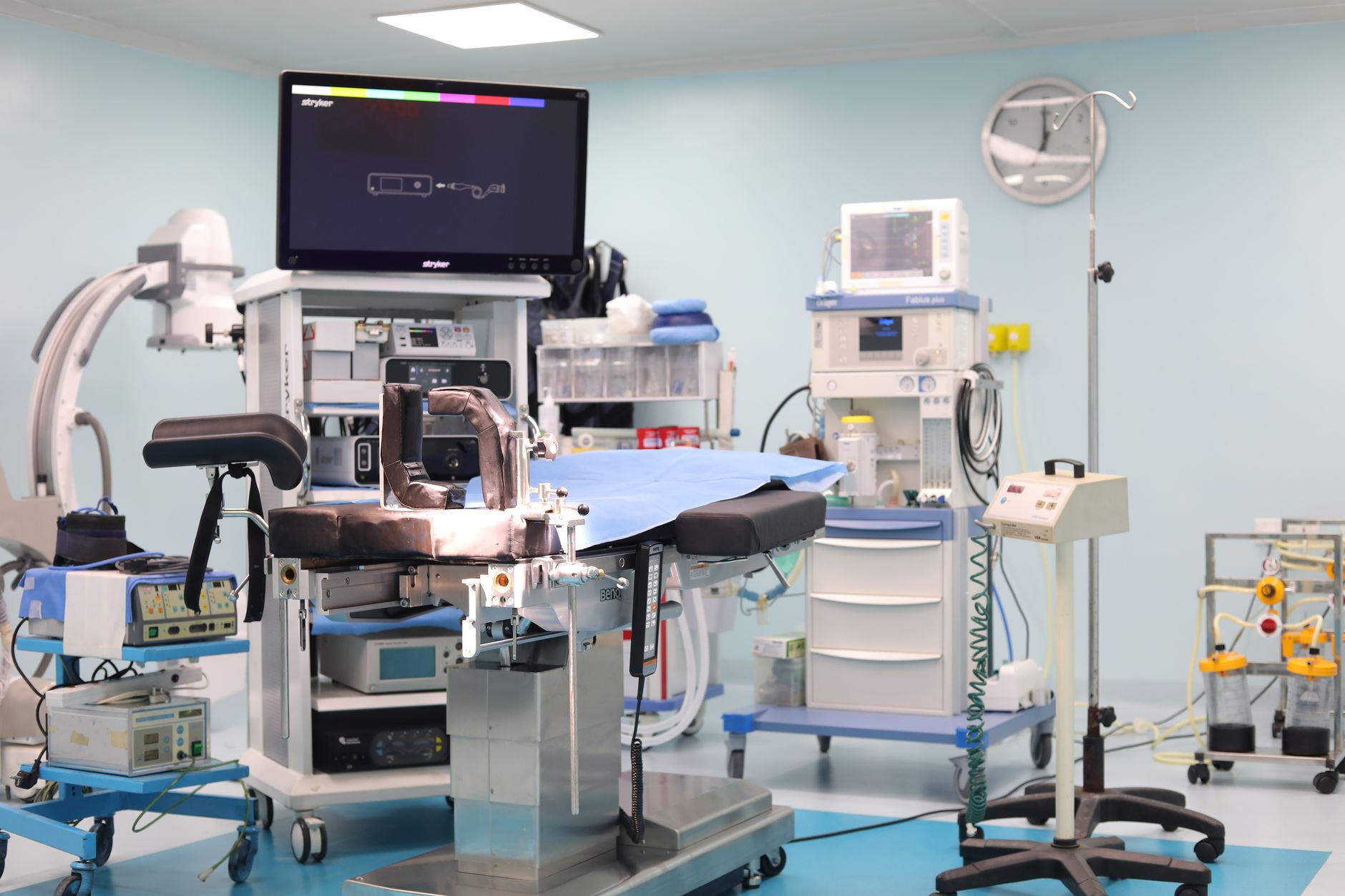 A modern hospital operating room prepared for a surgical procedure with anesthesia equipment visible