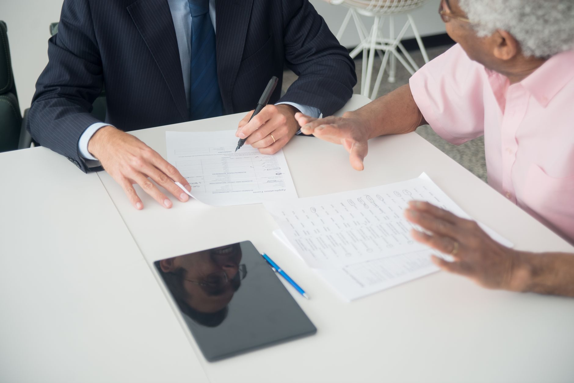 Financial advisor meeting with clients at a conference table in a modern office