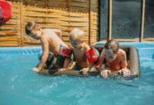 Children taking swimming lessons in an indoor pool at a local swim school