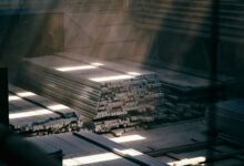 Large steel warehouse interior with stacked metal coils and industrial shelving