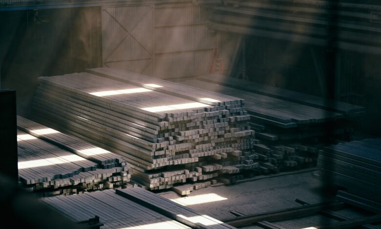Large steel warehouse interior with stacked metal coils and industrial shelving