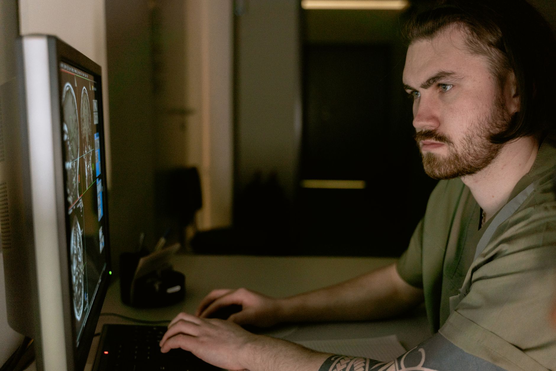 A radiologist reviewing medical imaging scans on a computer screen in a clinical setting