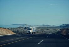 A commercial freight truck driving on a highway, representing regional shipping logistics