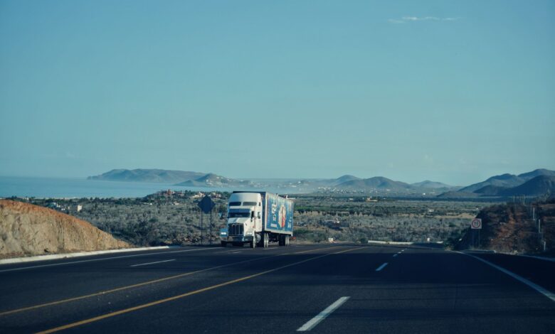 A commercial freight truck driving on a highway, representing regional shipping logistics