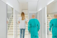 A clean, modern ambulatory surgery center corridor with medical equipment and overhead lighting