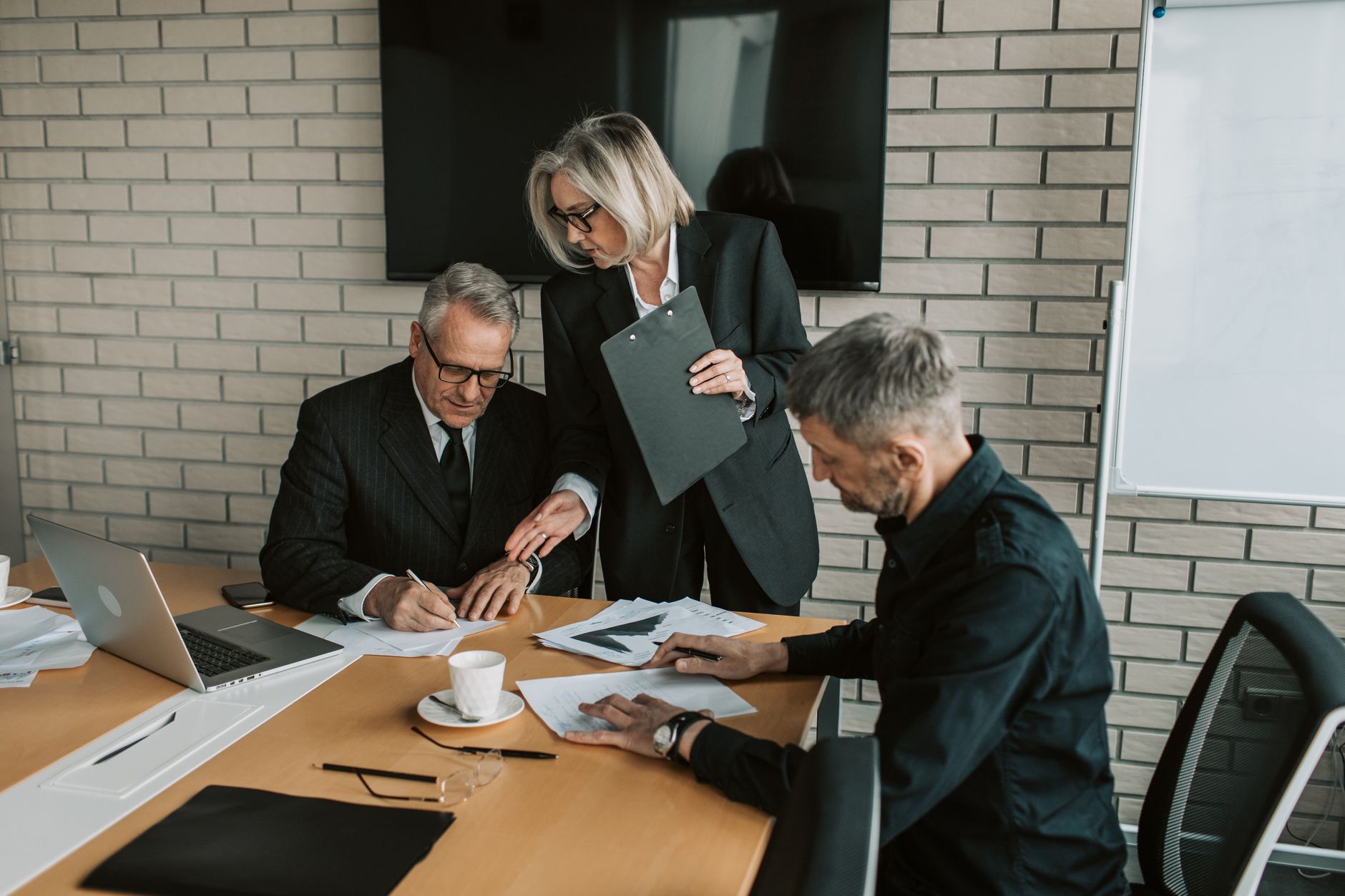 Healthcare executives reviewing documents in a conference room setting