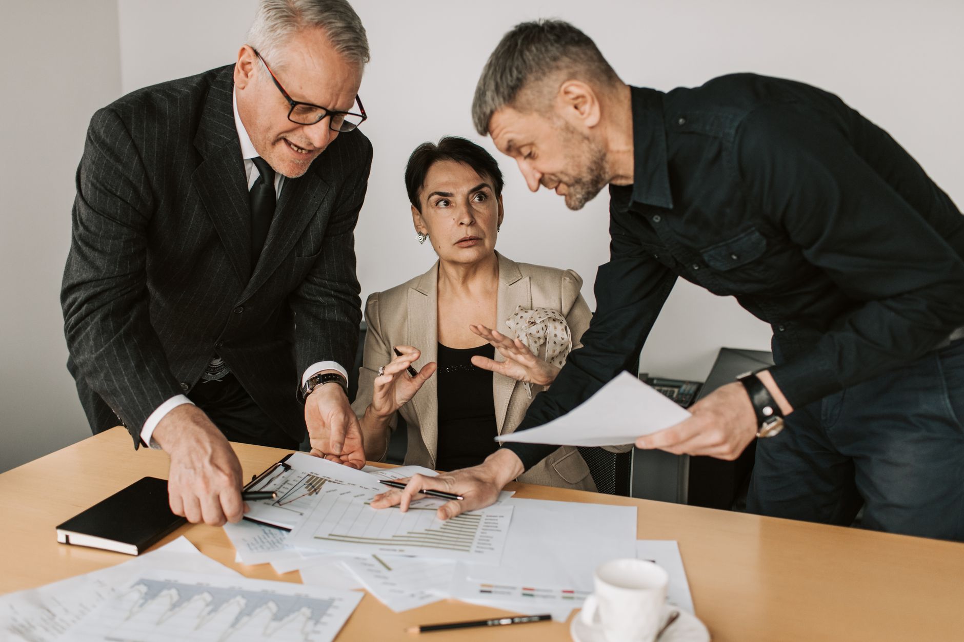 Business professionals reviewing documents during a corporate acquisition meeting