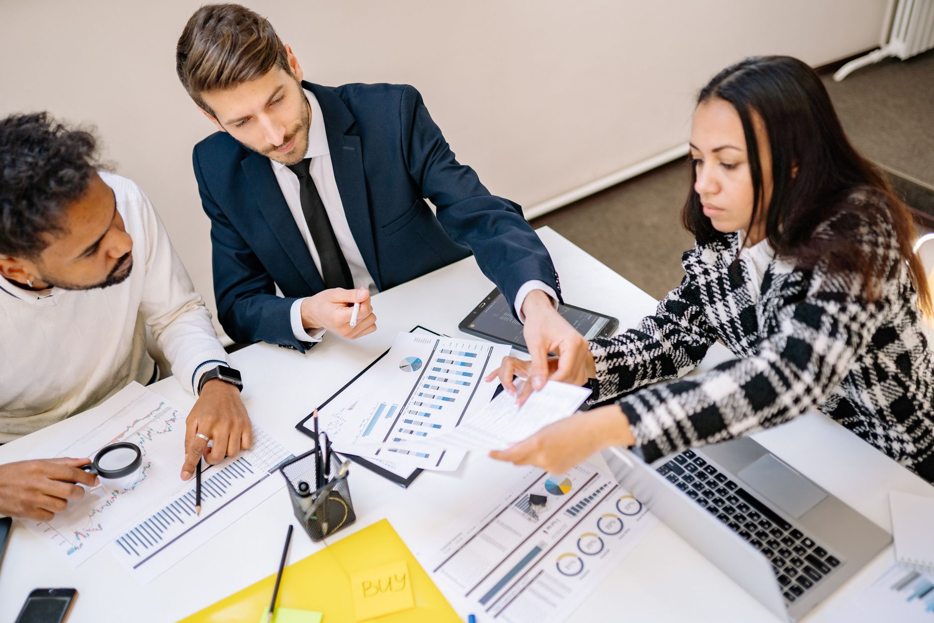 Business professionals reviewing acquisition documents at a conference table