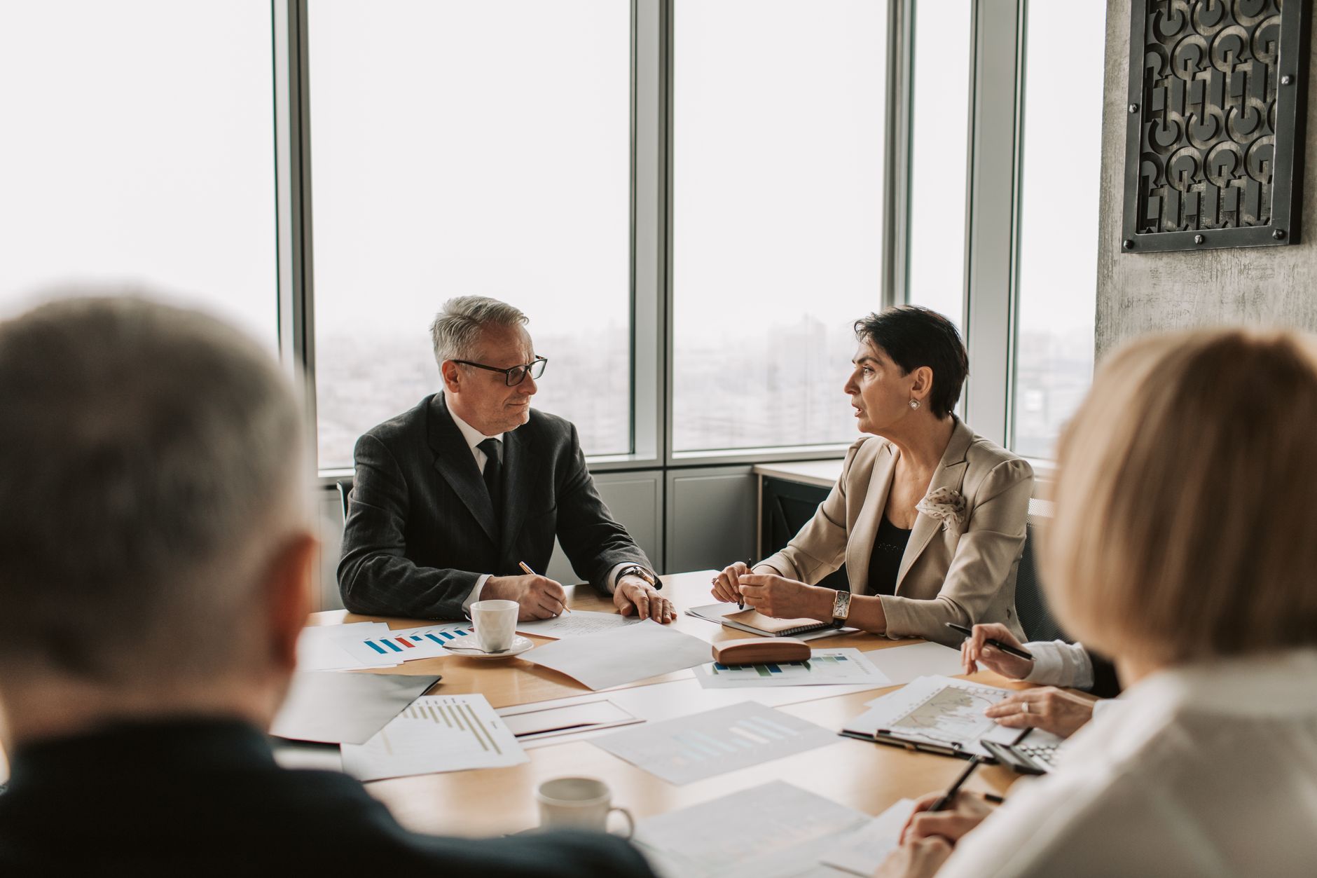 Healthcare executives meeting around a conference table in a modern hospital administrative office