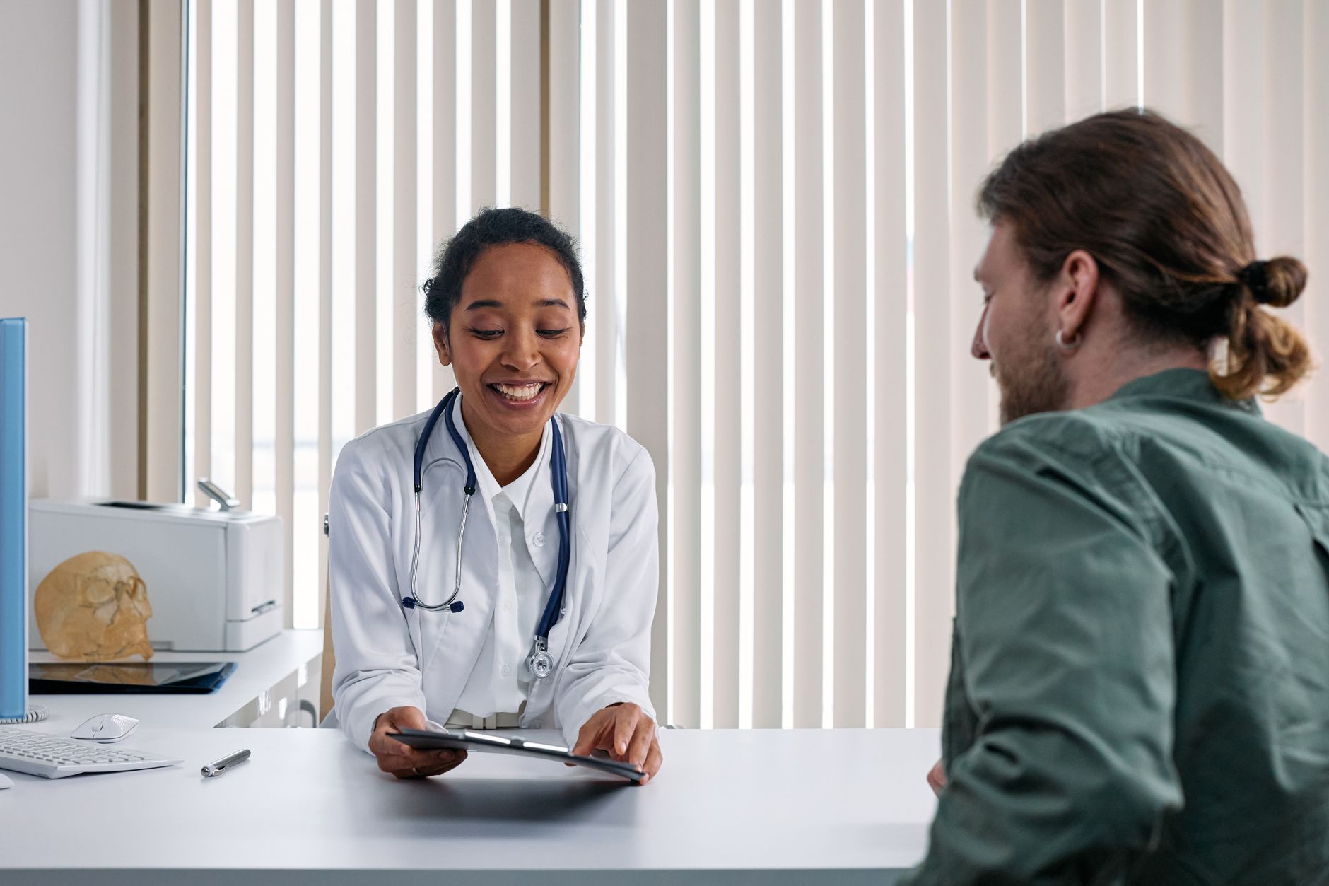 A physician consulting with a patient in a small clinical exam room