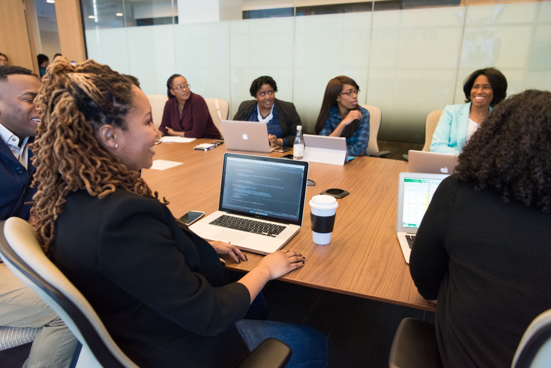 Corporate executives seated around a conference table reviewing documents