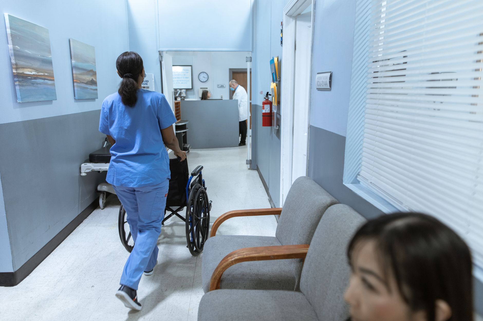 Healthcare workers walking through a clinical facility hallway