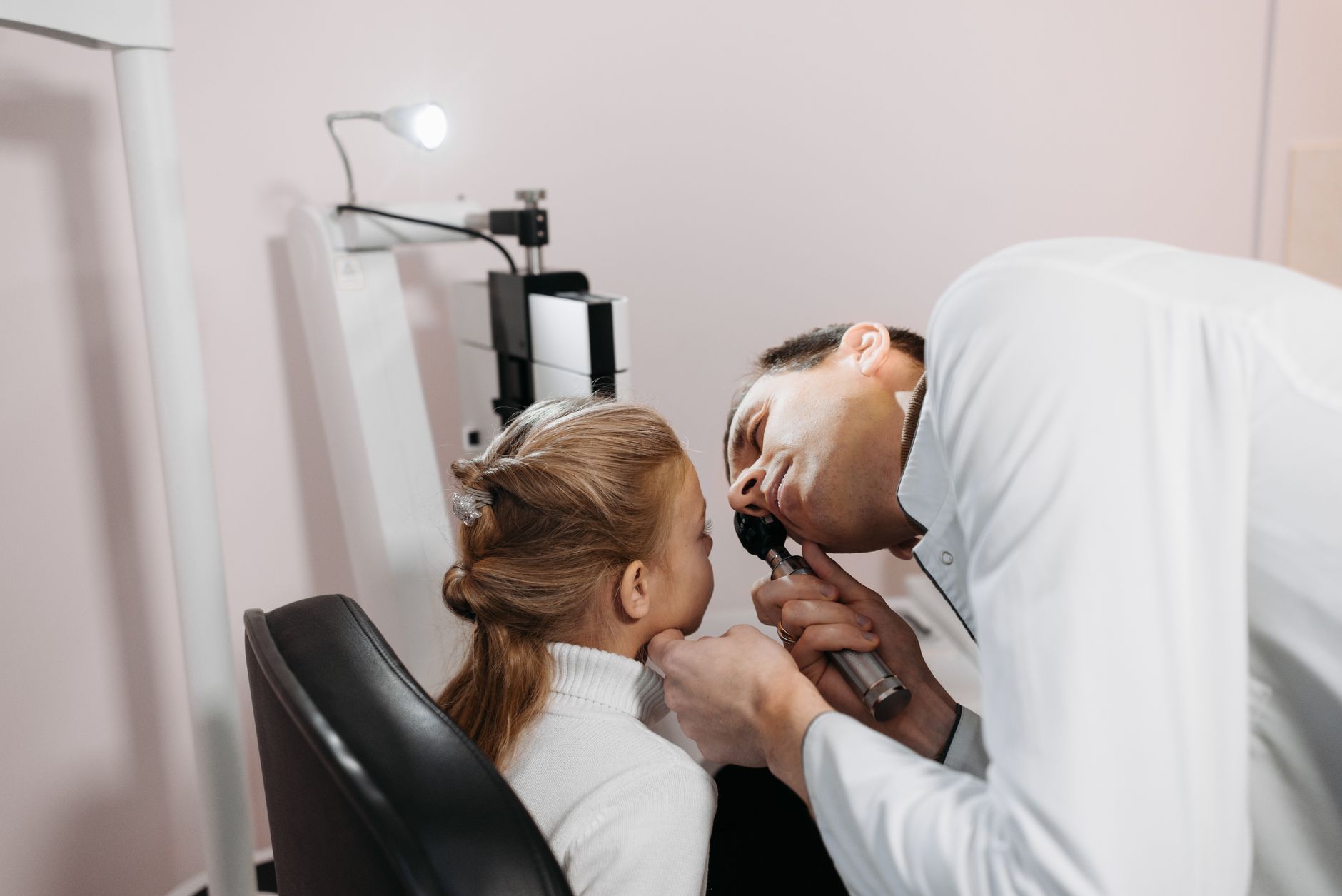 An optometrist conducting an eye examination in a clinical setting