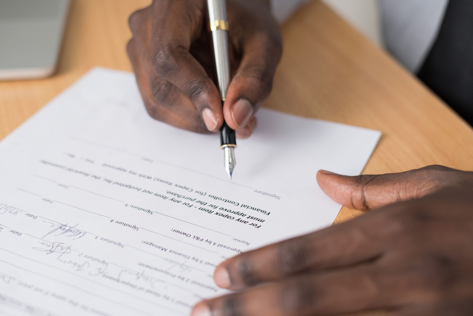 Two professionals reviewing and signing a business acquisition agreement