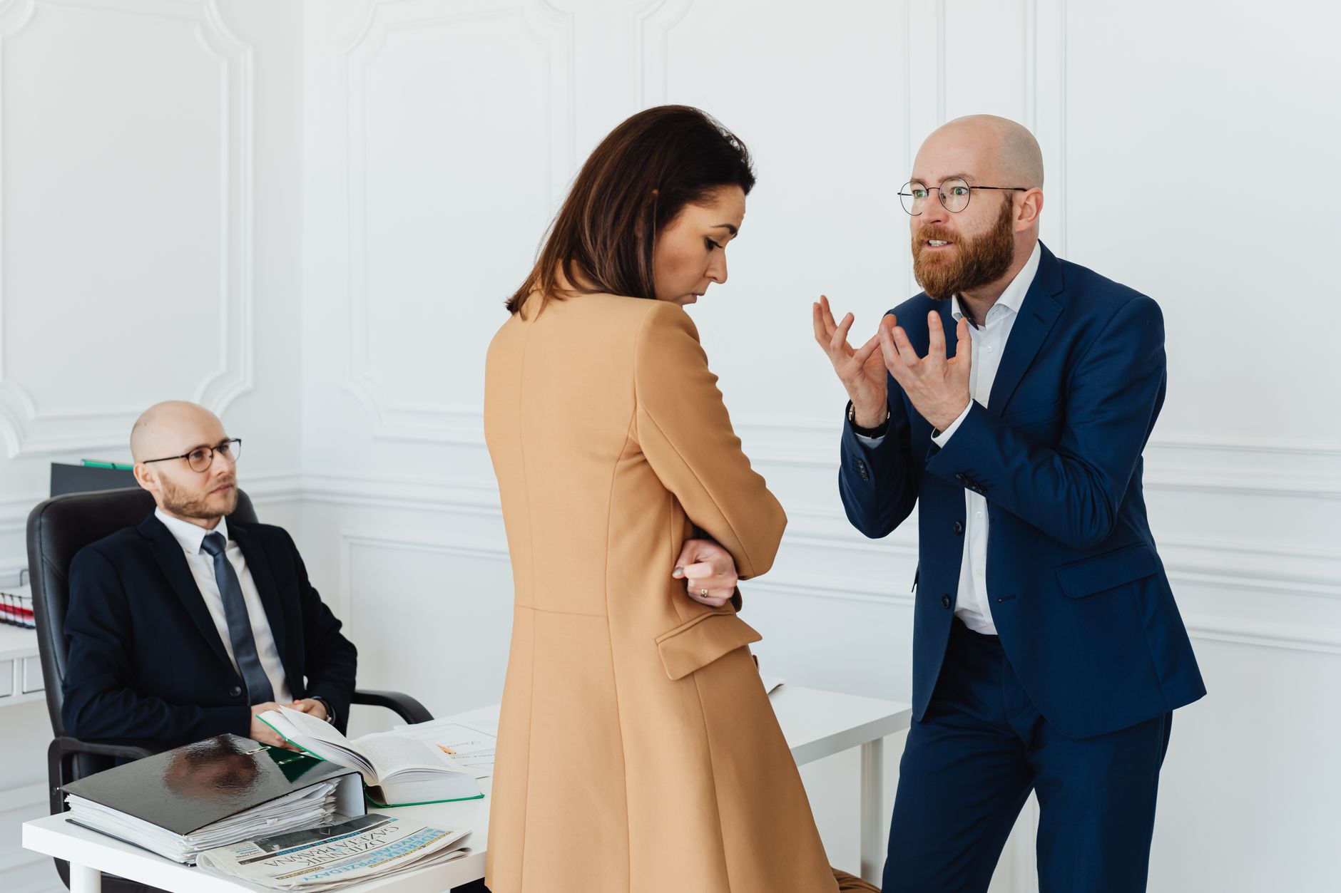 Two business professionals discussing documents at an office desk