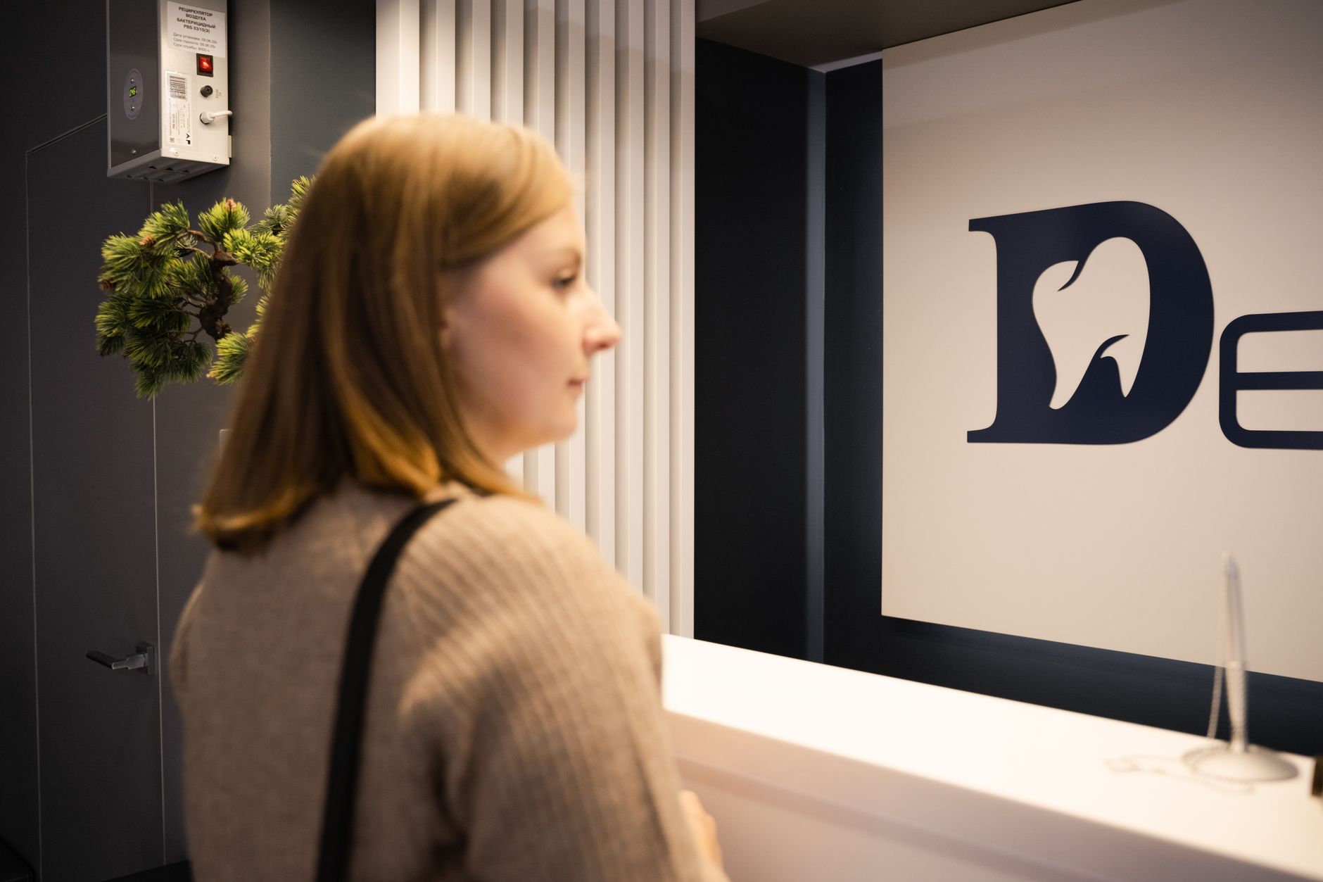 A modern medical office reception area with patients waiting