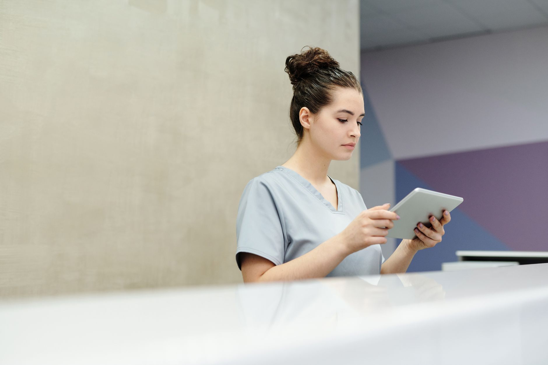 Healthcare administrator working at a desk in a clinical office environment