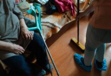 A caregiver sitting beside an elderly patient in a hospice setting