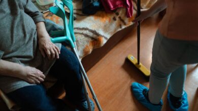 A caregiver sitting beside an elderly patient in a hospice setting
