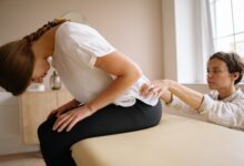 A clean, modern chiropractic treatment room with adjustment table and medical equipment