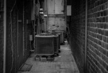 HVAC technician working on an outdoor air conditioning unit