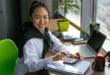 A business professional reviewing accounting software on a desktop computer in a modern office setting