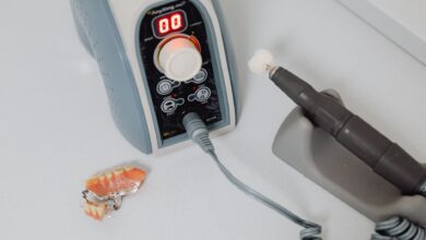 A dental laboratory technician working on prosthetic dental pieces at a workbench