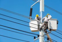 Electrician working on an industrial electrical panel at a commercial construction site