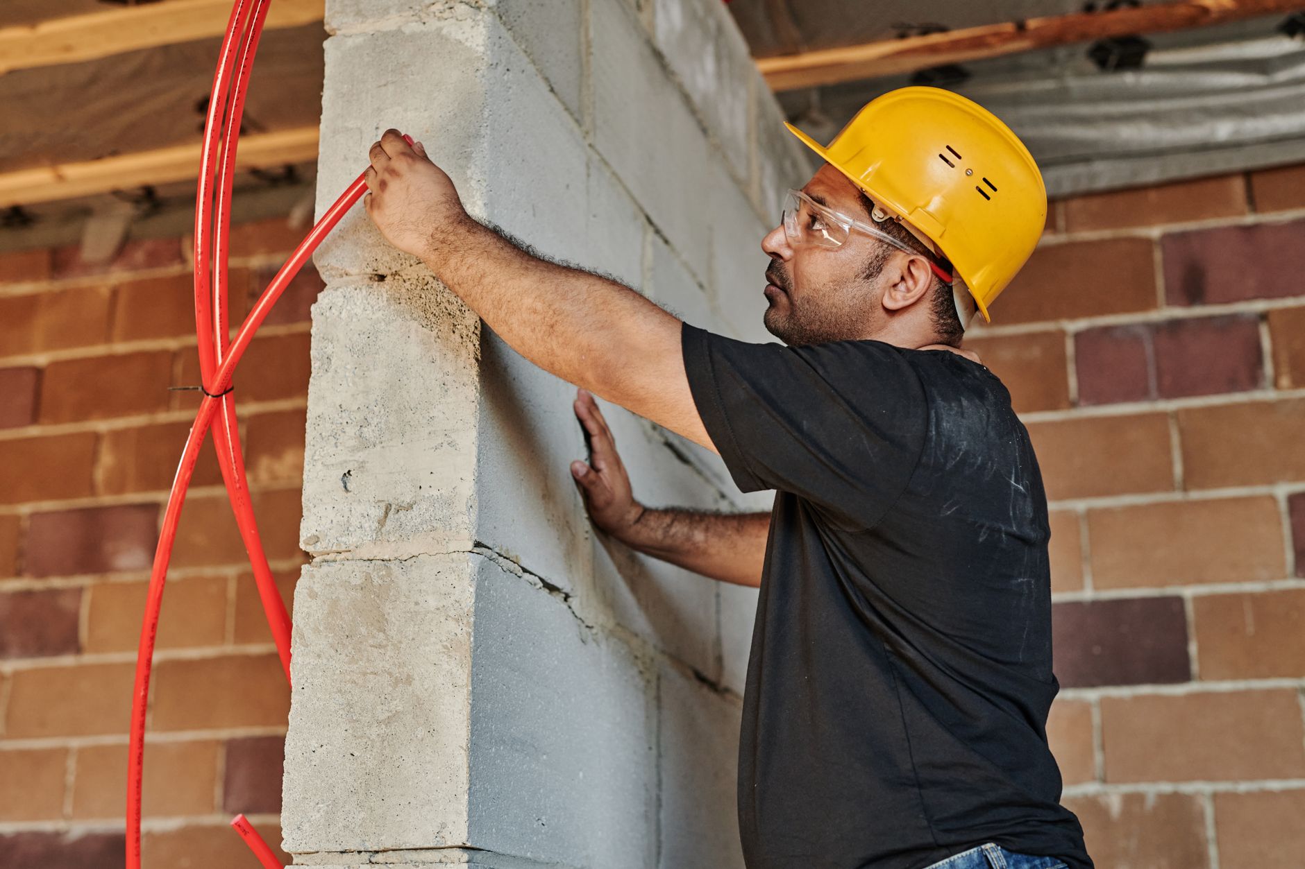 Electrician working on commercial wiring panel at a job site