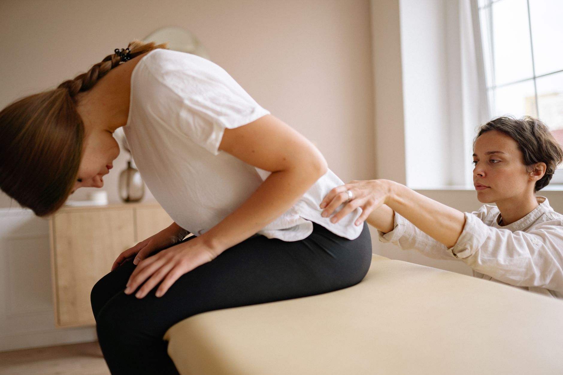 A clean, modern chiropractic treatment room with adjustment table and medical equipment