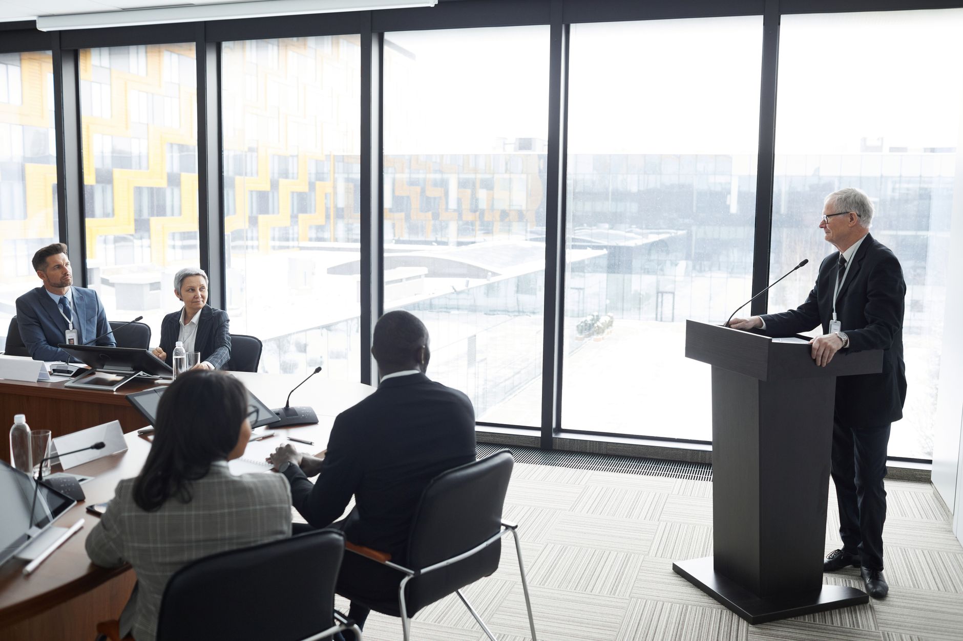 Business professionals reviewing documents and charts during a corporate acquisition meeting
