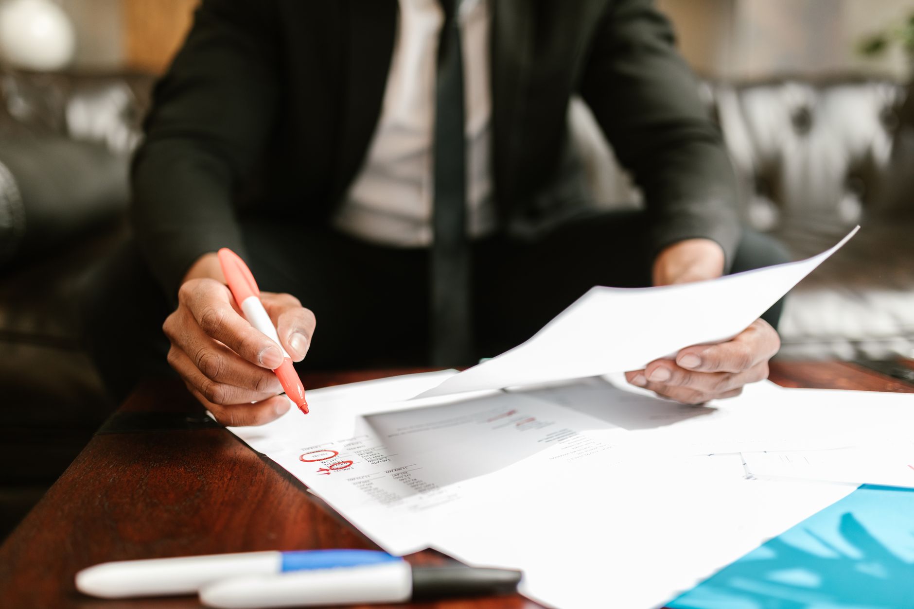 Two professionals reviewing documents at a conference table during a business meeting