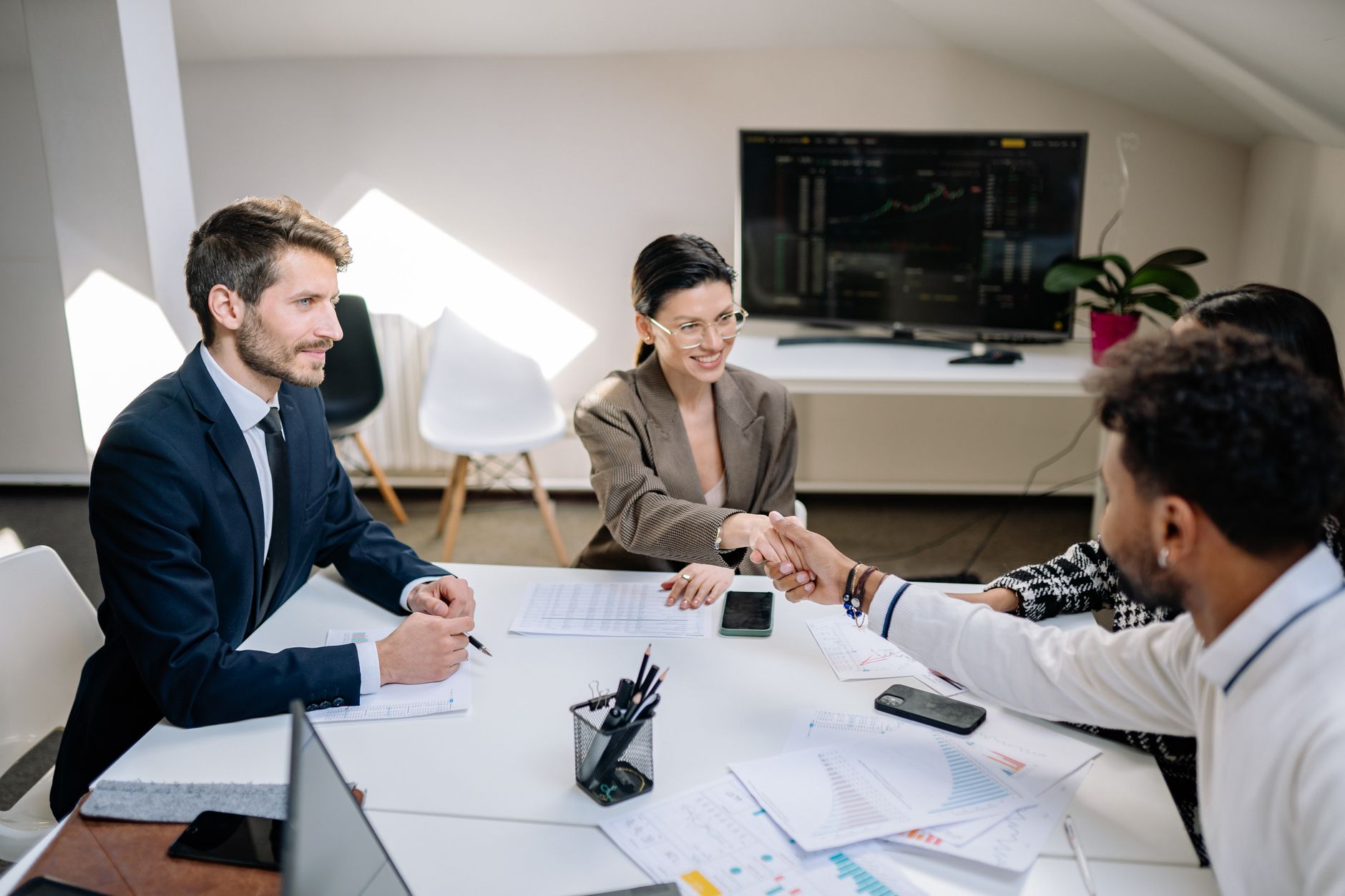 Business professionals reviewing documents and contracts during a corporate acquisition meeting