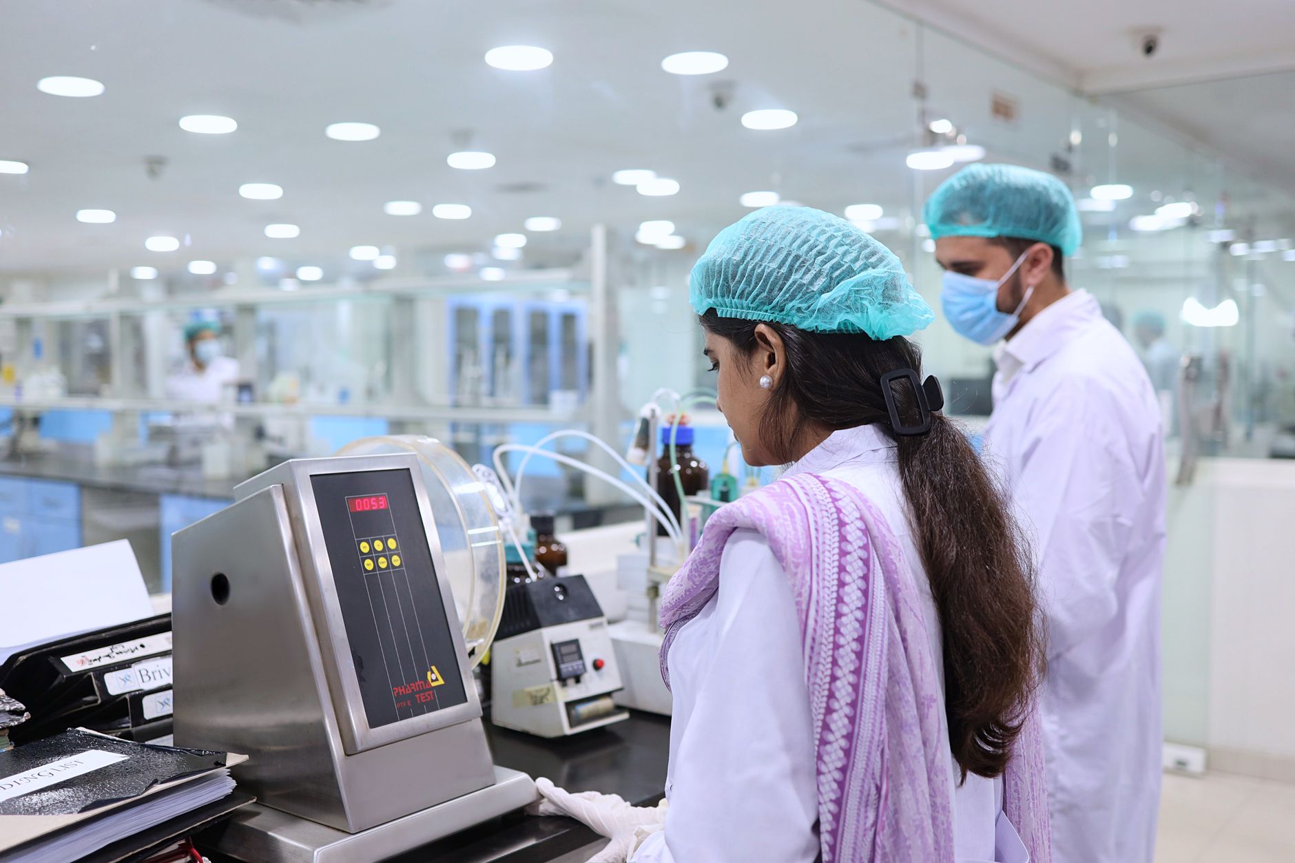 Technician working in a pharmaceutical compounding laboratory with sterile equipment