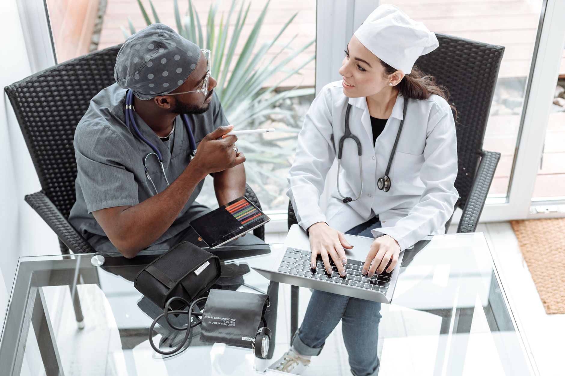 A group of physicians in a conference room reviewing documents during a practice meeting