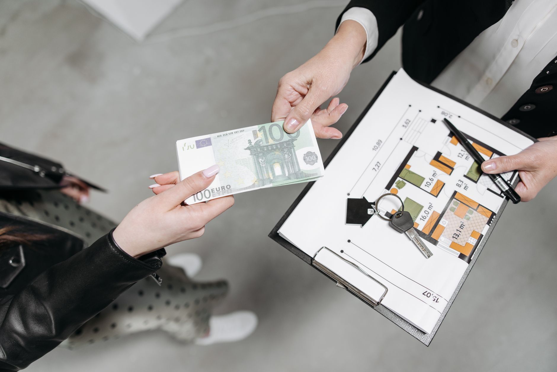 Person signing real estate or business contract documents at a desk