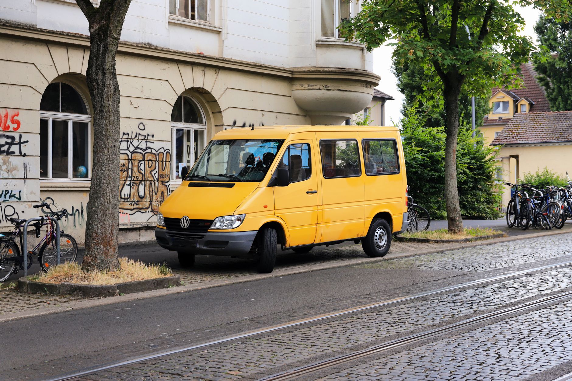 A branded plumbing service van parked outside a suburban home