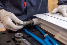 A plumber working on pipes beneath a sink in a residential home