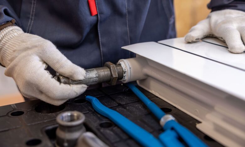 A plumber working on pipes beneath a sink in a residential home