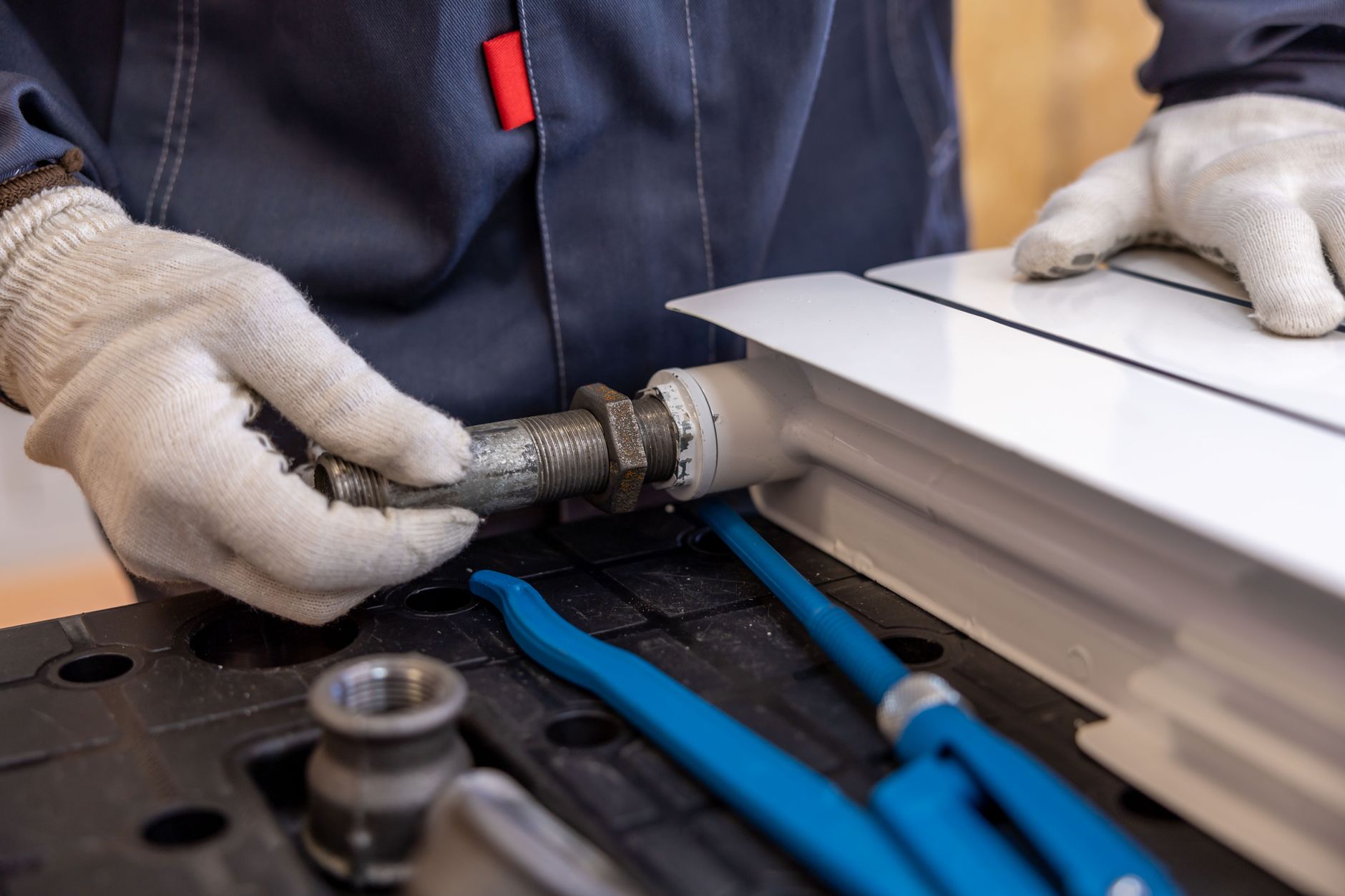 A plumber working on pipes beneath a sink in a residential home