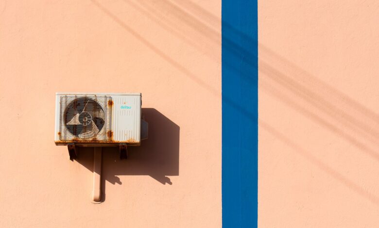 HVAC technician servicing an outdoor air conditioning unit at a residential property
