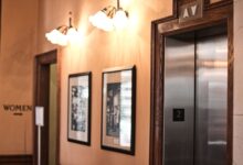 Modern elevator interior with steel doors and control panel in a commercial building