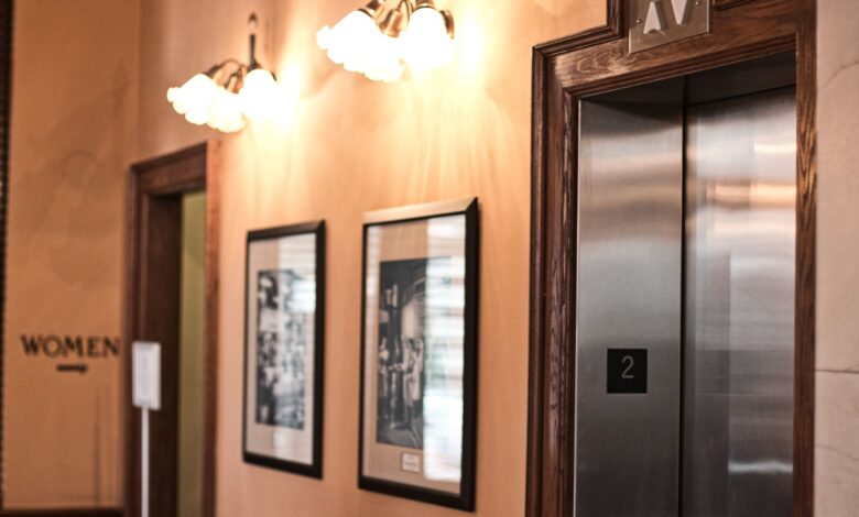 Modern elevator interior with steel doors and control panel in a commercial building