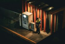 A uniformed security guard standing at the entrance of a commercial building
