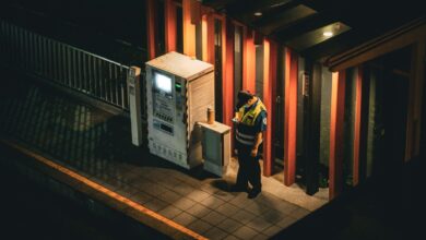 A uniformed security guard standing at the entrance of a commercial building