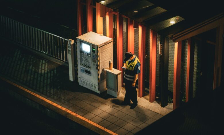 A uniformed security guard standing at the entrance of a commercial building